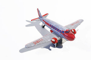 A toy model of a DC3 aircraft in silver and red colors, next to its packaging which has 'Overseas Airlines DC3' text.