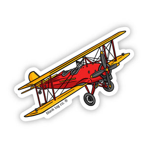 Sticker of a red and yellow biplane on a white background.