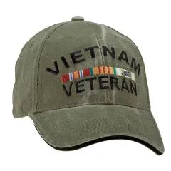 A green-colored baseball cap with 'VIETNAM VETERAN' text and veteran ribbons embroidered on the front.