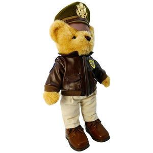 A plush toy bear wearing a military bomber jacket and hat, standing upright.