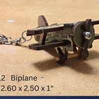 Metal keychain with die cut wood air[plane  on a brown background