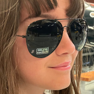 Black aviator sunglasses with 'Deluxe Edition' label.
