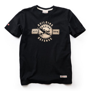 A black crew neck t-shirt with a vintage Boeing logo  printed in beige on the front, and 'Building Defense' est 1916