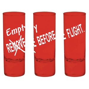 Three red glass shot glasses with the text 'EMPTY BEFORE FLIGHT' in white lettering and a cross mark over the text.