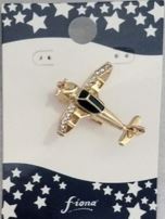 Gold airplane-shaped pin on a blue card with white stars