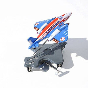 A toy airplane with a spring mechanism, predominantly blue with red and white accents, mounted on a chassis, displayed against a white background.