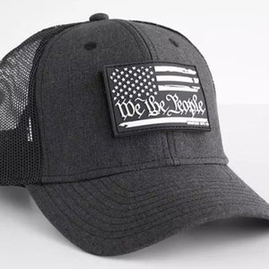 Black cap with American flag patch and 'We the People' text on a white background