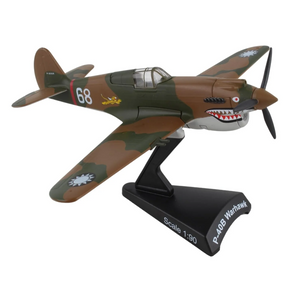A 1:90 scale model of a P-40S Warhawk toy airplane on a black display stand, featuring a green and brown camouflage paint scheme with a shark face on the nose and white markings.