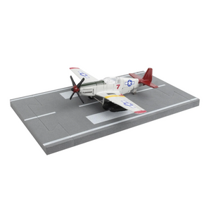 A miniature model of a vintage military airplane on a gray flight deck display base, photographed against a solid white background.