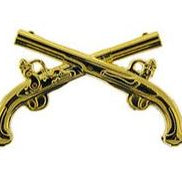 Two gold-colored metal pins shaped like pistols, crossed over each other.