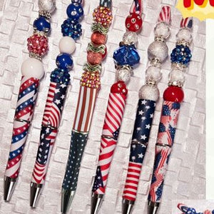 Decorative pens with American flag design on a textured surface