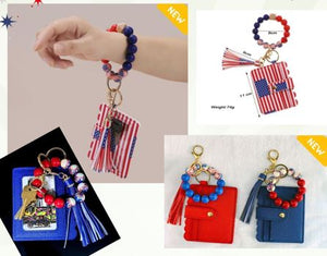 Keychain with American flag design and tassel, displayed on a hand and with additional keychains shown.
