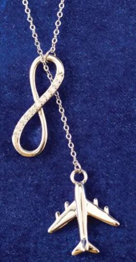 Silver airplane and infinity symbol necklace on a blue background