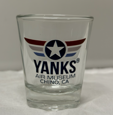 Clear glass shot glass with 'Yanks Air Museum Chino, CA' logo on a white surface.
