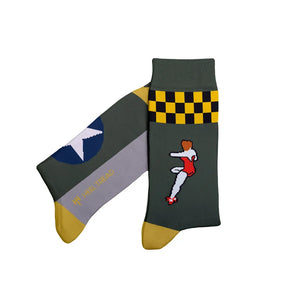 A pair of crew socks with a military-themed design. One sock features a dark olive green body with a yellow and black checkered stripe, a blue star insignia, and a pixelated soldier graphic.