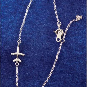 Silver airplane pendant on a chain against a blue background