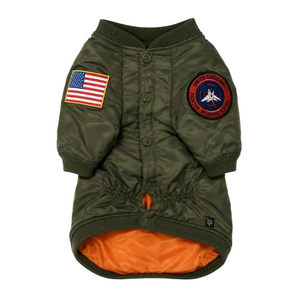 An olive green dog jacket styled like a military bomber jacket, featuring an orange interior lining, a button-up front, an American flag patch on the right sleeve, and a United States Navy Trooper We Poor Sheep patch on the left sleeve.