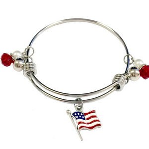 Silver bracelet with American flag charm and red and white beads on a white background