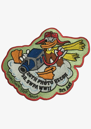 A patch featuring an illustration of Donald Duck with a camera, surrounded by text and a graphic representing the 26th Photo Recon Squadron and World War II.