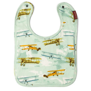 A bib with a vintage plane print, featuring adjustable straps and a ruffled edge.