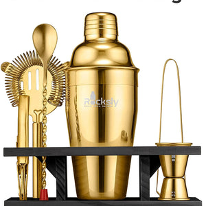 A set of gold-colored cocktail shakers and tools including a shaker bottle, a strainer, a jigger, and a spoon, displayed on a black stand with 'SLEAKY MODERN DESIGN' text overlay.
