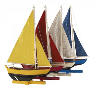 A set of four colorful sailboats with yellow, red, blue, and white sails, displayed on a stand.