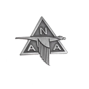 A silver-colored pin shaped like a stylized bird with the letters 'NA' at the top and 'A' at the bottom, representing North American Aviation.