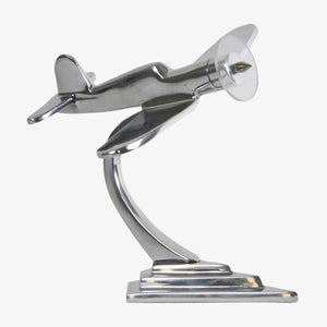 A silver aluminum desktop Corsair paperweight in the shape of a WWII era fighter plane.