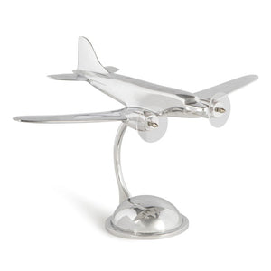 A silver highly polished model of a DC-3 airplane on a stand.