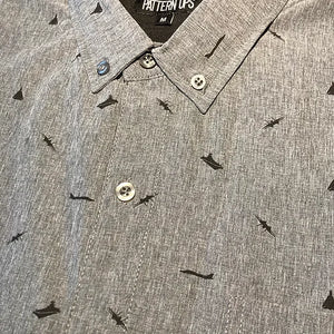 Close-up of a grey shirt with black F-14 Tomcat silhouettes and aircraft carriers printed across the fabric.