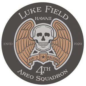 A round black sticker with a design featuring a skull, wings, and text that commemorates the Luke Field 4th Aero Squadron.