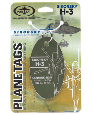 A Sikorsky H-3 Yanks Plane Tag made from retired aircraft fuselage, with a green background featuring an illustration of the helicopter and its details. The tag has a metal ring for attachment and is labeled with 'SIKORSKY' and 'H-3' designations.