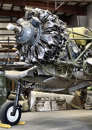  Donate to the restoration F4U Corsair aircraft on display, with visible signs of wear and restoration needed.